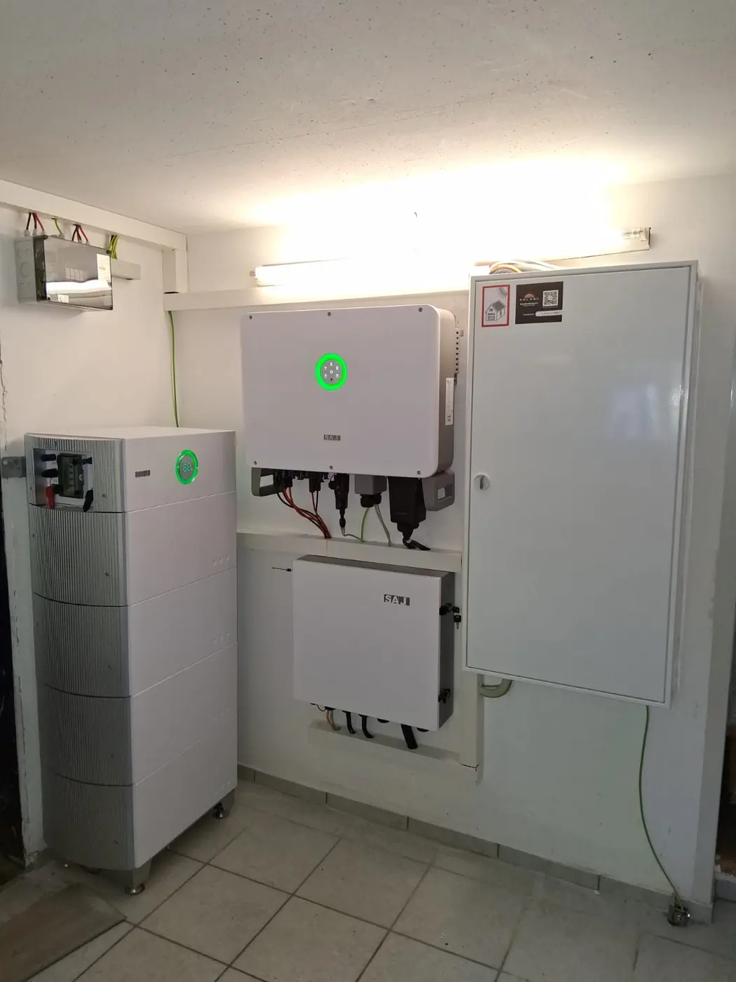 SolarX – Stromspeicher und Wechselrichter nebeneinander an der Wand eines Technikraums Stromspeicher und Wechselrichter nebeneinander an der Wand eines Technikraums