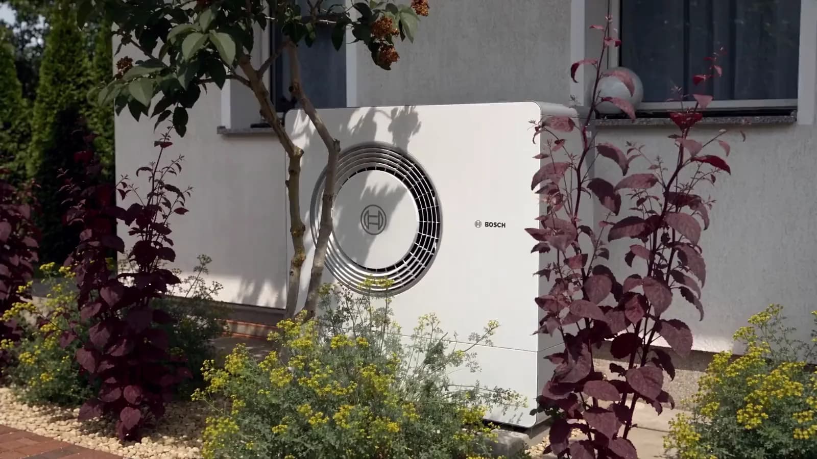 SolarX – Außeneinheit einer Wärmepumpe am Haus Wärmepumpe an einer Hauswand